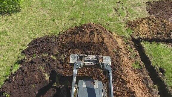 草地上推土机、挖掘机挖掘基坑的架空