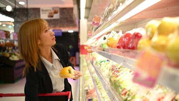 美丽的亚洲女人在超市购物