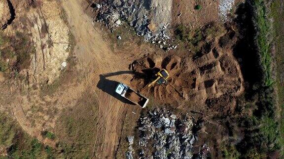 挖掘机将地面装填到自卸卡车上的鸟瞰图