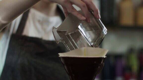 可爱的日本咖啡师倒磨碎的咖啡豆