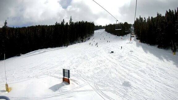 带座位的滑雪缆车可以看到人们在斜坡上滑雪和滑雪板慢动作