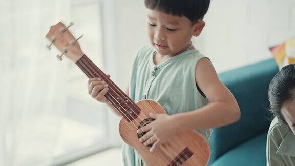 快乐的亚洲家庭在家里唱歌和弹吉他