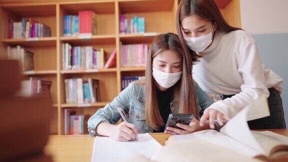 女大学生在大学图书馆看书和写书