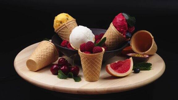 冰淇淋蛋筒有各种各样的水果和冰淇淋口味在桌子上旋转自制杯装覆盆子香草冰淇淋食品与广告理念
