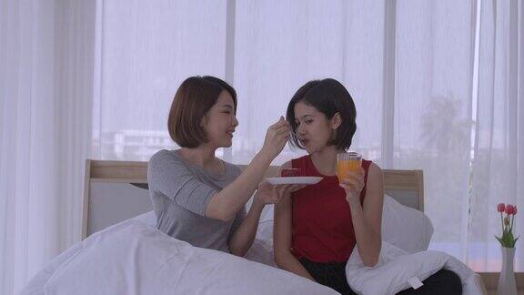 两个女人喝着橙汁一起吃着奶油蛋糕