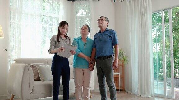 房地产经纪人正带着一对亚洲老夫妇参观他们即将购买的房子房地产经营理念退休生活