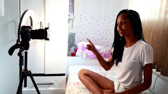 有影响力的黑人少女拿着三脚架在镜头前说话少女在社交媒体上制作视频