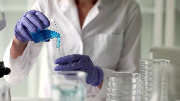 科学家化学家将蓝色液体凝胶倒入实验室的试管中