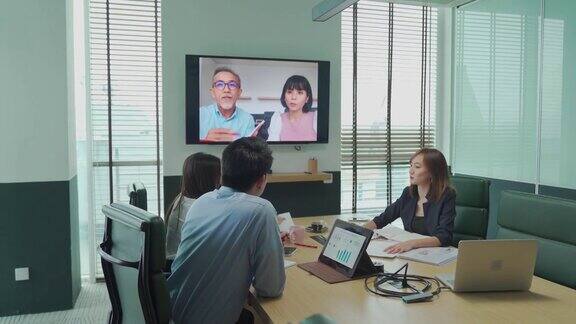 亚洲白领与公司员工进行视频会议会议讨论在会议室董事会与外国投资者进行视频会议公司并购业务会议