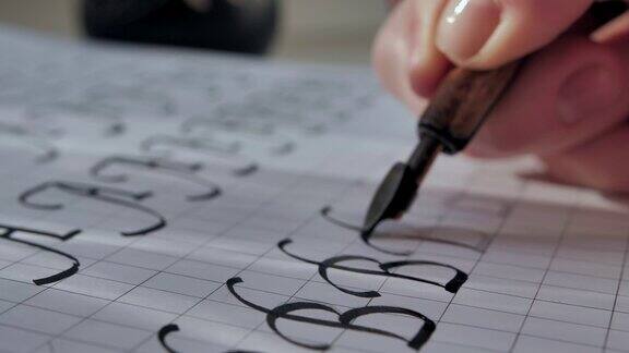 书法在阳光下用笔尖钢笔写字用黑墨水在白纸上写字大写字母b电影特写