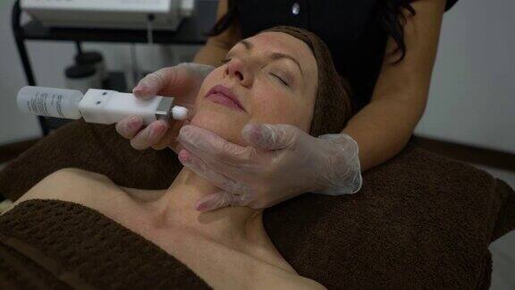 美容师正在为女性顾客做面部电疗