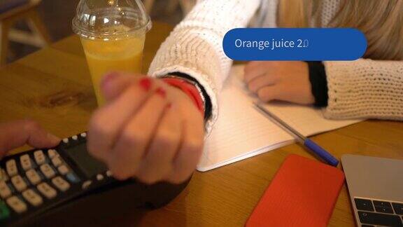 十几岁的女孩在咖啡馆用智能手表支付非接触式