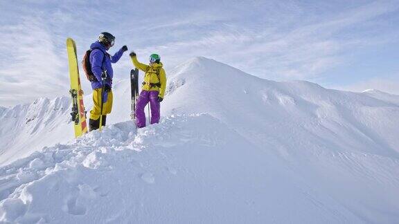 两个偏远地区的滑雪者在山脊上碰拳