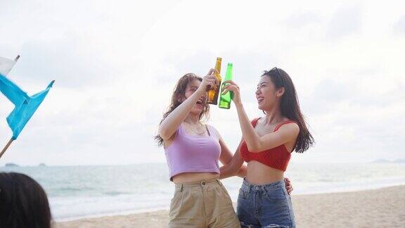 亚洲年轻漂亮的女人朋友在海滩上聚会在一起迷人的两个女人旅行者唱歌和跳舞在海边露营享受假期的热带海岛度假旅行