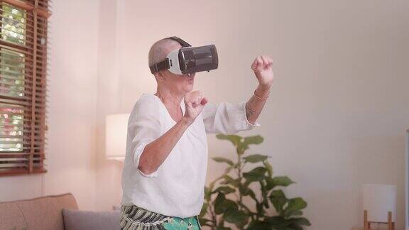 快乐的老妇人放松地用虚拟现实眼镜打游戏