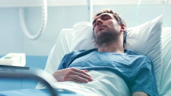 医院里生病的男病人躺在床上睡觉手指上戴着心率监测器明亮现代的医疗病房