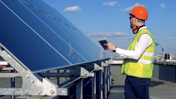 太阳能电池板正在接受一位男性工作服专家的检查