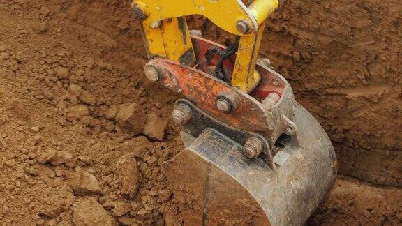 一个强大的挖掘机的铲斗从坑中清除泥土铺设管道