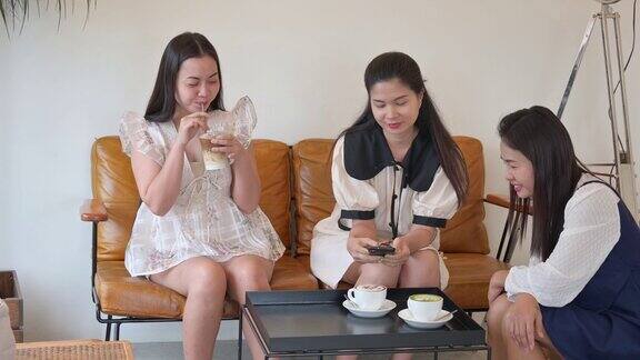 一个亚洲女人在咖啡店和朋友们聊天