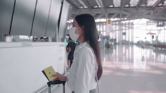一名商务女性在国际机场戴着防护口罩在新冠肺炎疫情下旅行安全旅行社交距离礼仪新常态旅行理念