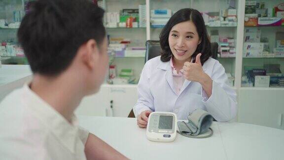 一名亚洲女药剂师正在给一名男性患者做血压测试