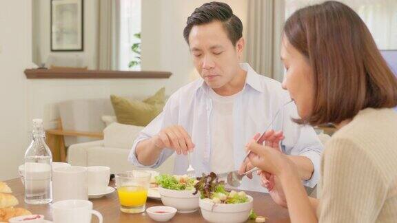在家里一个可爱的年轻人和他的女朋友正在餐桌上享用早餐