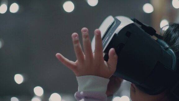 亚洲小女孩在虚拟现实头盔在家
