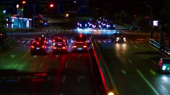 青山斜交的城市街道上的小型交通堵塞的夜间时间推移