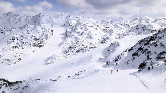 空中情侣在阳光明媚的日子从斜坡上滑雪