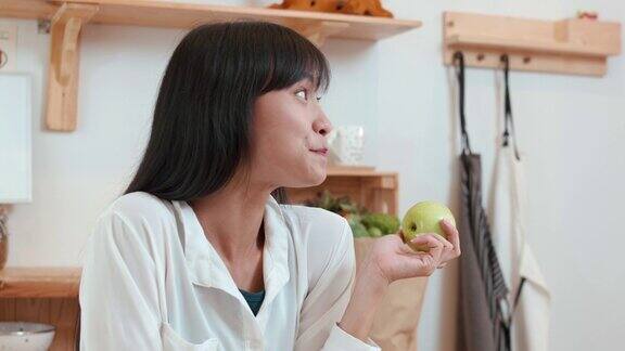 长发女人在厨房里咬苹果