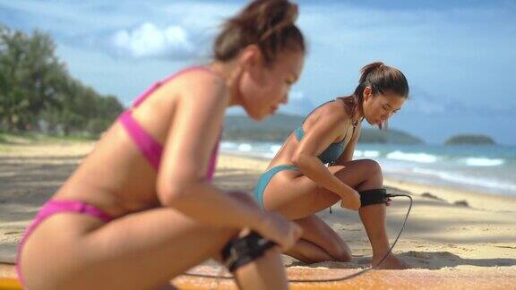 4K一群亚洲女性戴着冲浪板安全绳一起在海里冲浪