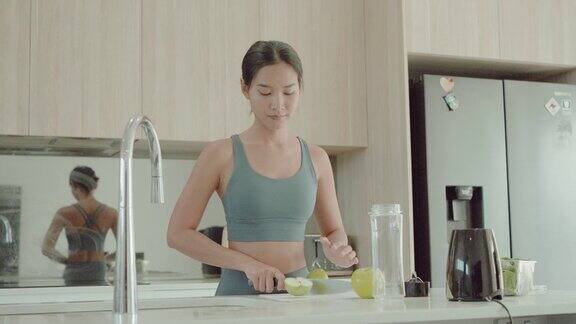 年轻的亚洲女性在锻炼后制作绿色排毒奶昔健康的生活方式