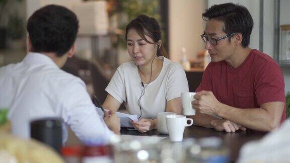 一对亚洲的中国夫妇正在咨询他们房子里的保险代理人