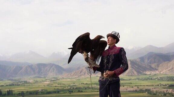 鹰猎人站在吉尔吉斯斯坦山脉的背景