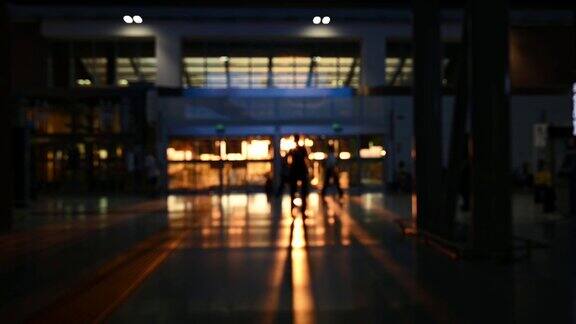 (离焦视频)日落时分一些游客在机场候机楼里行走的模糊剪影Covid-19大流行期间的旅行理念