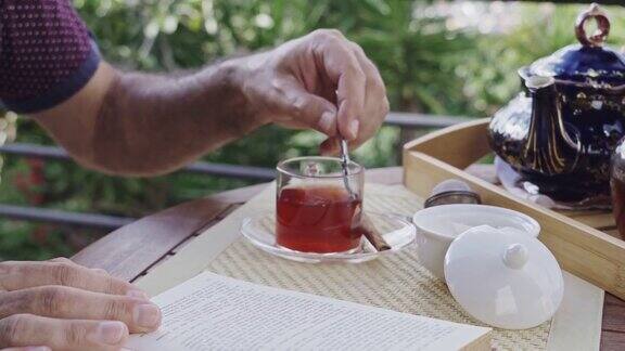 近距离观看在室外阳台上高级手把糖倒入热茶杯