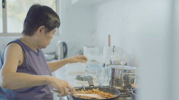 亚洲老年妇女在家做饭活跃老年退休生活