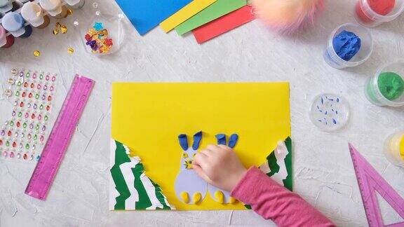 儿童制作卡片与复活节兔子玩具从彩色的纸和橡皮
