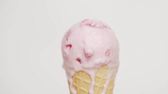 近距离观看草莓味的冰淇淋在蛋筒上融化