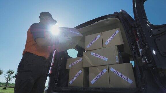 快递员将新型冠状病毒感染的货物包裹装进货车