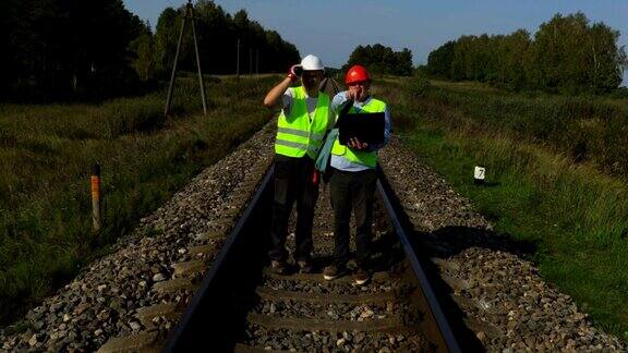 铁路工程师与助手检查铁路轨道