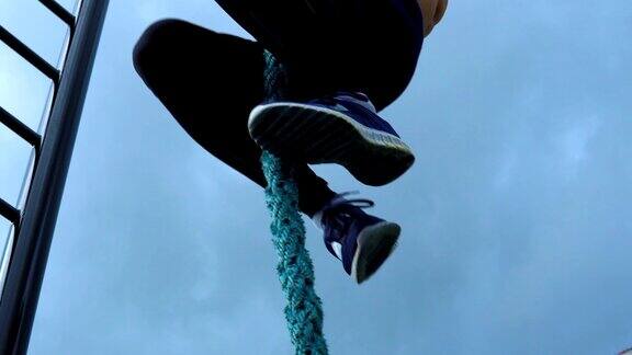一个年轻的运动员爬上了绳子