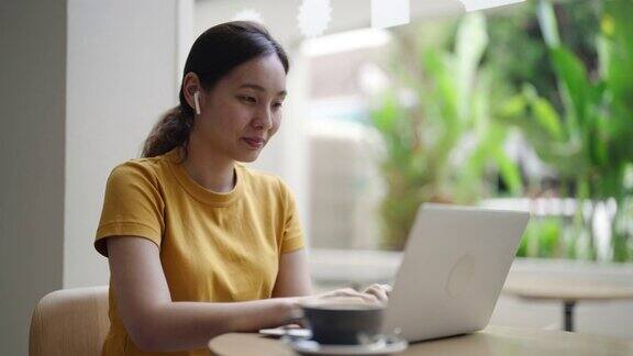 亚洲女性在咖啡馆使用笔记本电脑