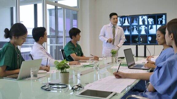 4K亚洲医生团队在会议室开会他们正在讨论病人的x光结果并寻找诊断