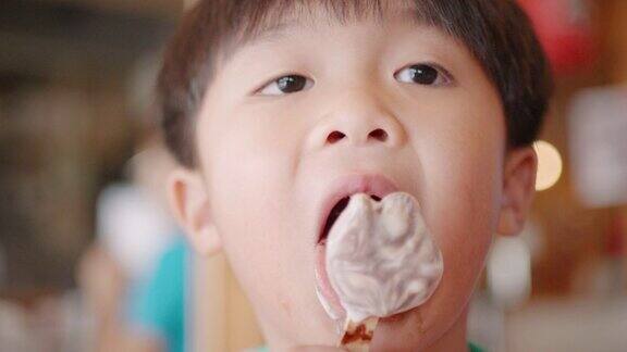 亚洲男孩在餐厅吃巧克力冰淇淋