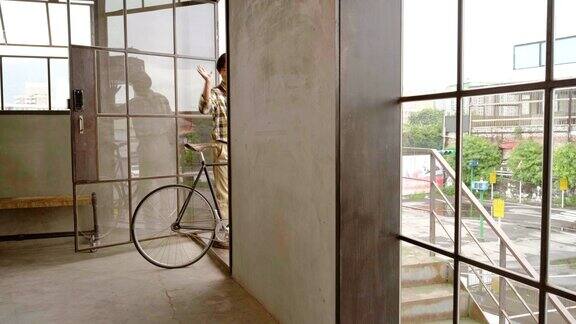 现代工人离开办公室与自行车作为一个包裹递送
