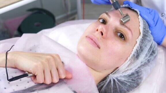 美容师为年轻女性的脸部做微电流手术
