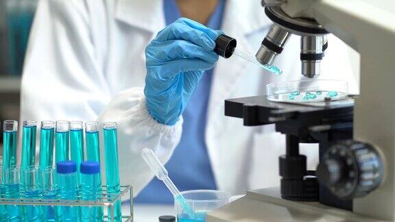 科学和医学科学家分析并将样品放入玻璃器皿中实验室中含有化学液体的玻璃器皿实验创新和技术