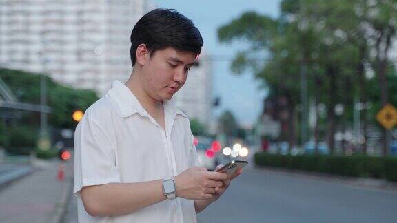 一个年轻人在街上使用智能手机