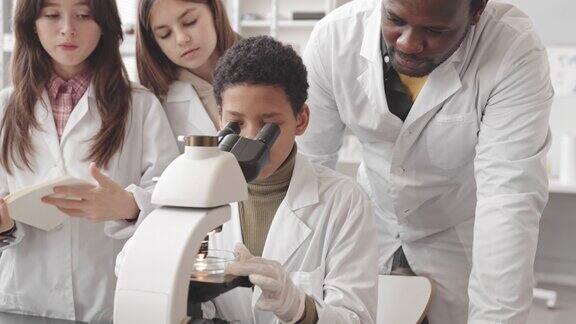 女学生在科学课上使用显微镜